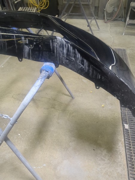 Bumper repair in progress — panel on stand
