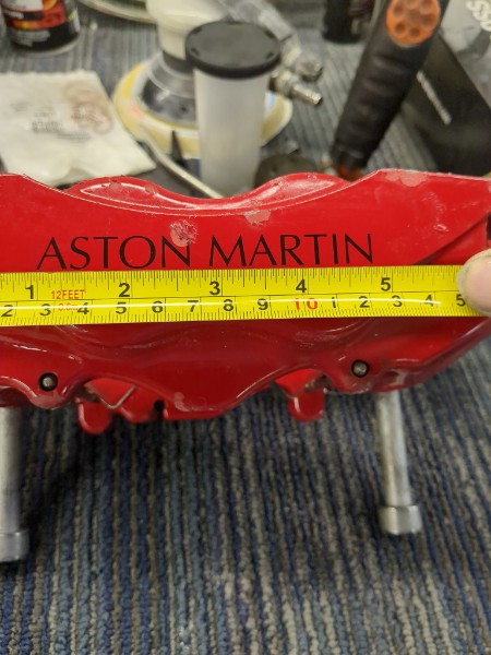 Close-up of Aston Martin caliper with measuring tape