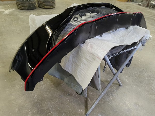 Rear bumper with custom red accent line being painted