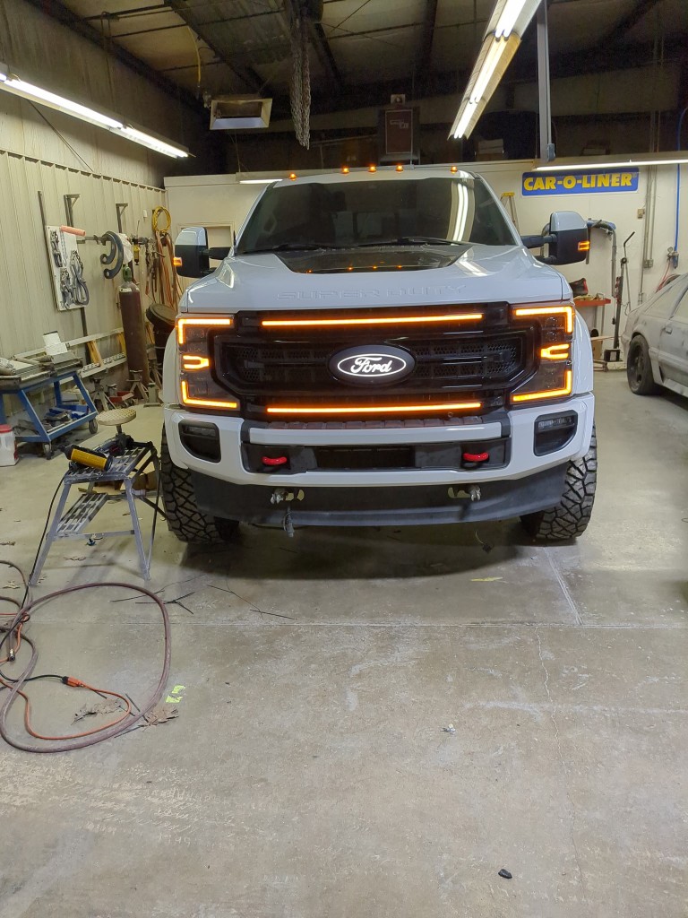 2021 Ford F-450 Limited — front view in shop with new grill and amber lights