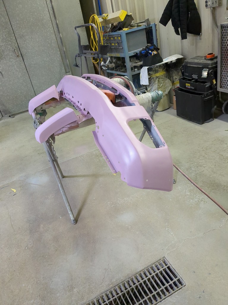 Front bumper in primer on paint stand